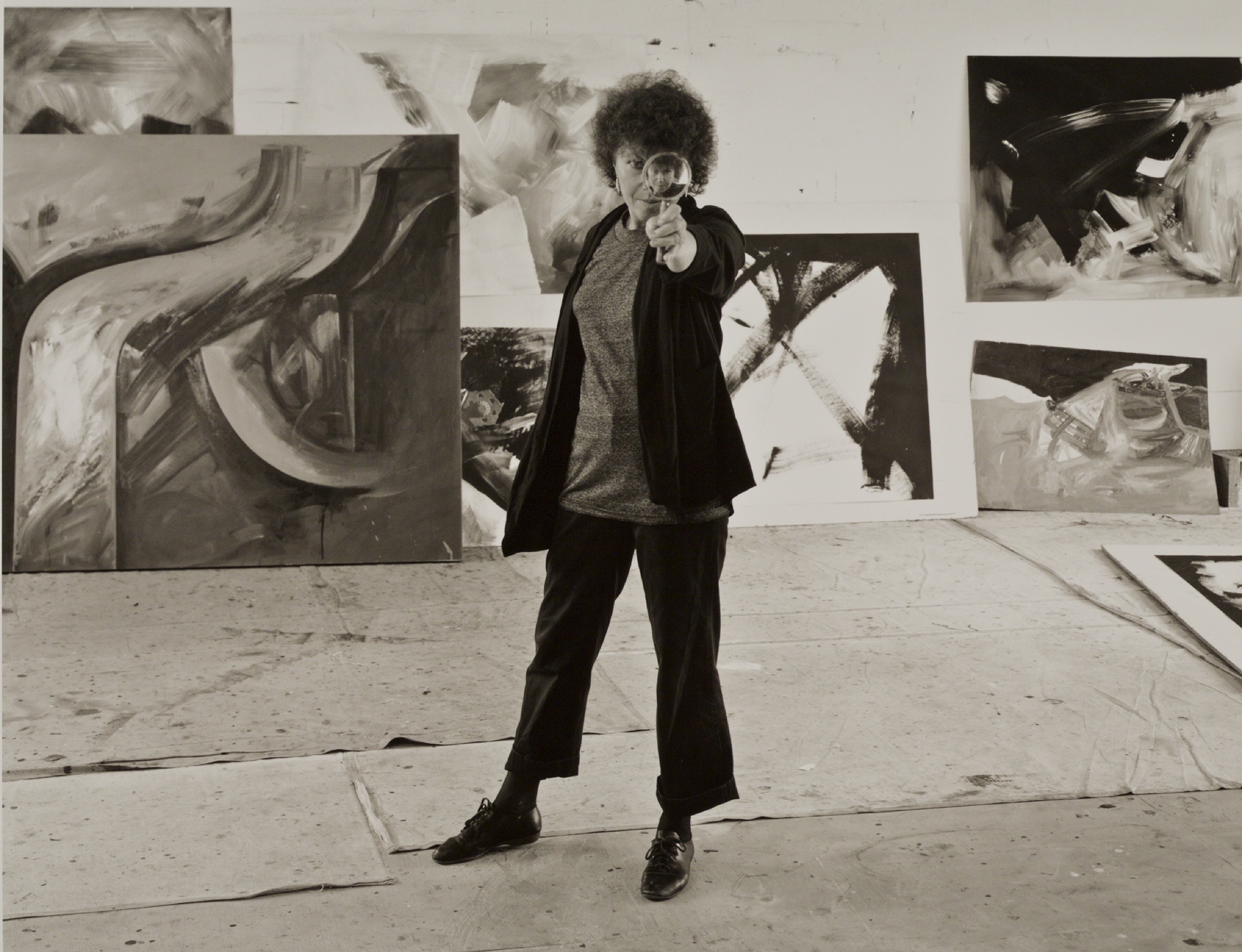 M. Lee Fatherree, Jay DeFeo in her Oakland studio with reducing glass, 1986